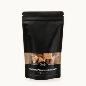 Cranberry-Pekanuss Cantuccini in schwarzer Emily's-Verpackung vor fast weißem Hintergrund